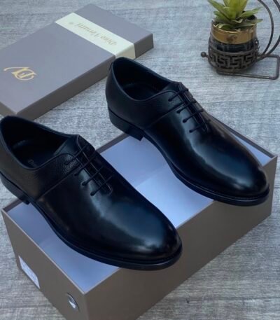 High-quality black leather oxford shoes on a shoe box, perfect for formal occasions.