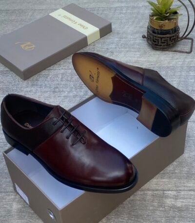 A pair of luxurious dark brown leather shoes with sleek design and elegant packaging, perfect for formal occasions.