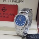 A luxurious Patek Philippe watch with a blue face and diamond-encrusted bezel, presented in an elegant box.