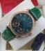 A luxurious Patek Philippe watch with a green face and leather strap, presented in a white box with a red card.