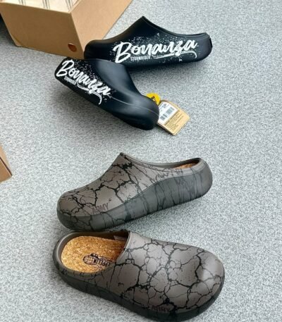 A pair of stylish clogs in black and grey marble finish, showcasing the brand name and logo.