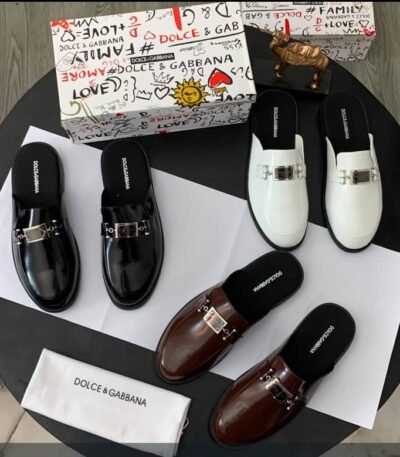 A luxurious display of Dolce & Gabbana loafers in black, brown, and white, accompanied by the brand's signature box and cloth.